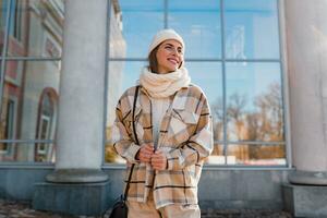 young smiling woman walking in street in winter photo