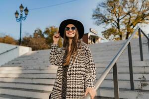 attractive young woman walking in autumn wearing coat photo