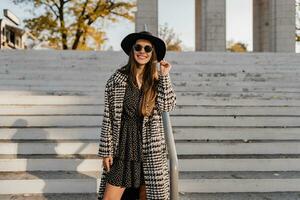 attractive young woman walking in autumn wearing coat photo