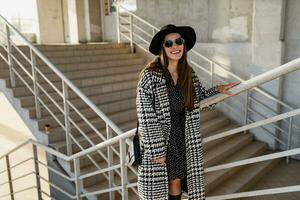 attractive young woman walking in autumn wearing coat photo