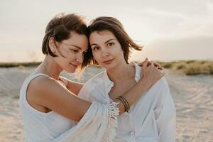 two young women having fun on the sunset beach photo