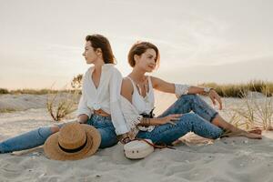 dos joven mujer teniendo divertido en el puesta de sol playa foto