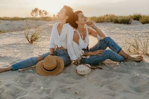 two young women having fun on the sunset beach photo