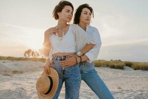 two young women having fun on the sunset beach photo