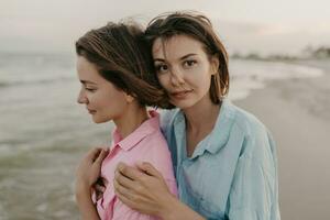 dos joven mujer teniendo divertido en el playa foto