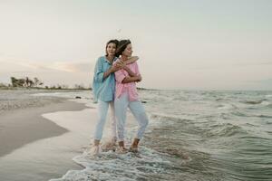 two young women having fun on the beach photo