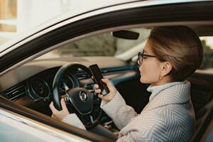 attractive stylish woman sitting in car dressed in coat photo