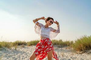 stylish attractive slim smiling woman on beach in summer style fashion trend outfit photo