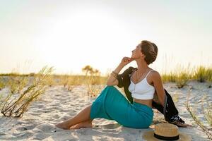 stylish attractive woman on beach in summer style fashion trend outfit happy having fun photo