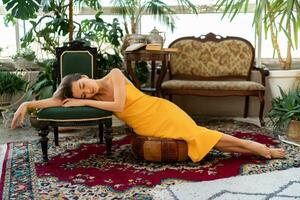attractive woman in yellow summer dress in boho style interior room photo