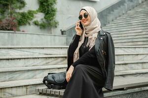 moderno elegante musulmán mujer en hijab en ciudad calle foto