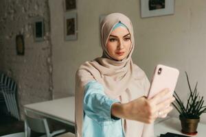 modern muslim woman in hijab in office room photo