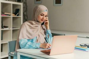 modern muslim woman in hijab in office room photo