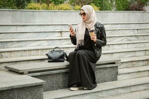 modern stylish muslim woman in hijab in city street photo