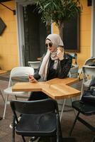 modern stylish muslim woman in hijab in city street photo