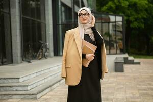 modern stylish muslim woman in hijab in city street photo