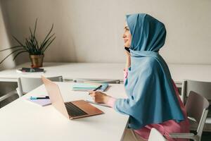 moderno musulmán mujer en hijab en oficina habitación foto