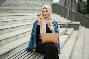 modern stylish muslim woman in hijab in city street photo