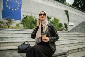 modern stylish muslim woman in hijab in city street photo