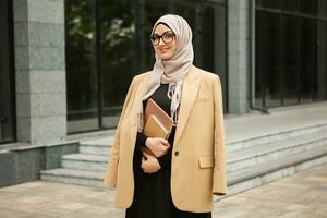 modern stylish muslim woman in hijab in city street photo