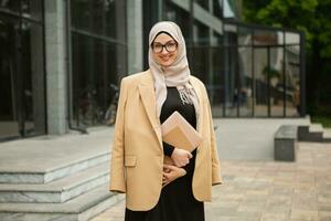 modern stylish muslim woman in hijab in city street photo