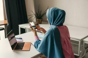 modern muslim woman in hijab in office room photo