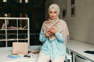 muslim woman in hijab working in office room photo