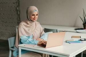 modern muslim woman in hijab in office room photo