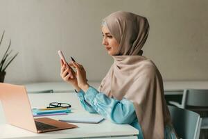 modern muslim woman in hijab in office room photo