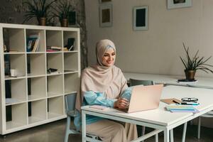 modern muslim woman in hijab in office room photo