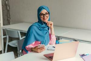 modern muslim woman in hijab in office room photo