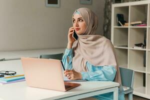 modern muslim woman in hijab in office room photo