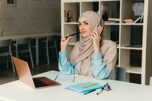 musulmán mujer en hijab trabajando en oficina habitación foto