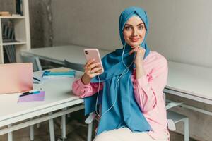 modern muslim woman in hijab in office room photo