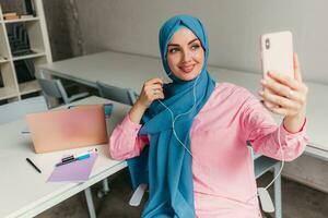 moderno musulmán mujer en hijab en oficina habitación foto