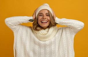 young smiling happy pretty blond woman wearing white knitted sweater, scarf and hat photo