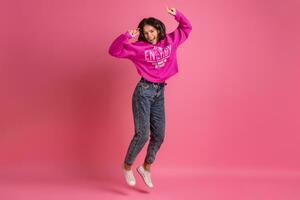 hispanic pretty woman in pink hoodie smiling jumping photo