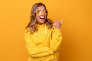 young pretty blonde woman cute face expression posing in yellow hoodie photo