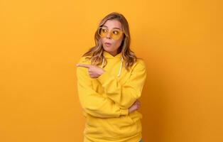 young pretty blonde woman cute face expression posing in yellow hoodie photo