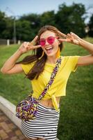 young stylish woman having fun in city park, summer style fashion trend photo