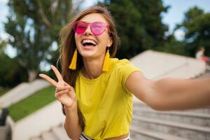 young stylish woman having fun in city park, summer style fashion trend photo