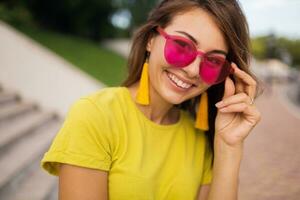 young stylish woman having fun in city park, summer style fashion trend photo