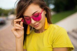 young stylish woman having fun in city park, summer style fashion trend photo