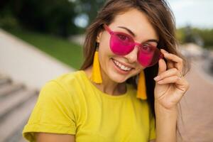 young stylish woman having fun in city park, summer style fashion trend photo