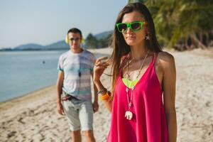 young beautiful couple walking on tropical beach photo