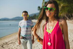 young beautiful couple walking on tropical beach photo