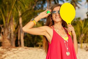 young hipster woman playing ping-pong on tropical beach, summer vacation. photo