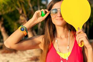 young hipster woman playing ping-pong on tropical beach, summer vacation. photo