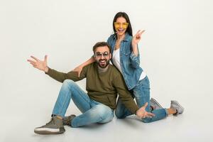 elegante Pareja sentado en piso en pantalones foto