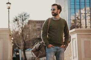 hipster hombre caminando en calle con bolso foto